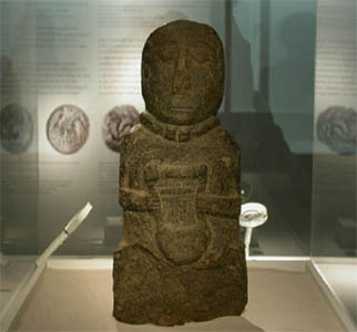 Statue of Iron Age 'bard' clutching a Celtic lyre, or 'Crwth'. The lyre was common to the Greeks from an early period. 